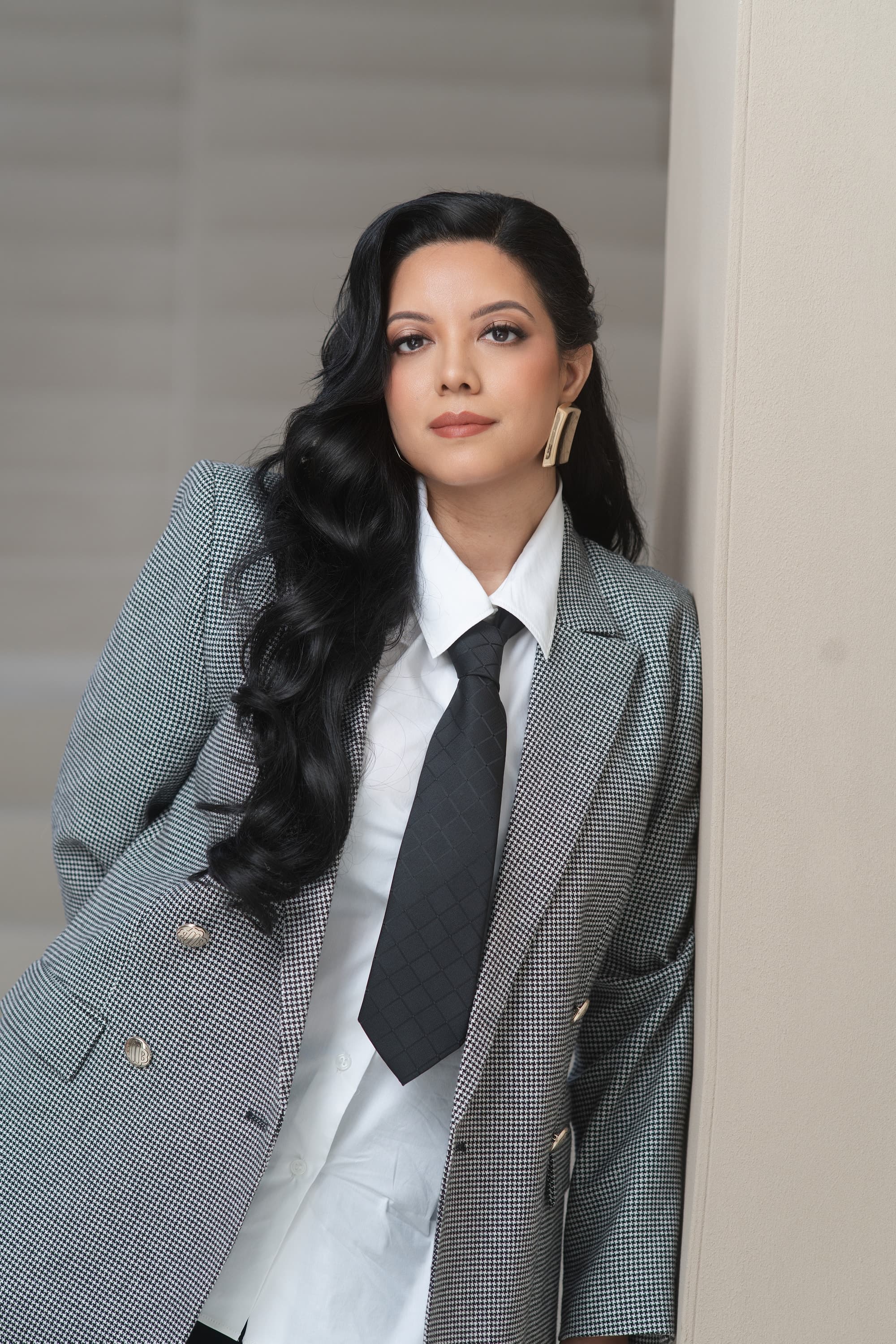 Priscilla Laclé wearing a checked blazer, white shirt and black tie