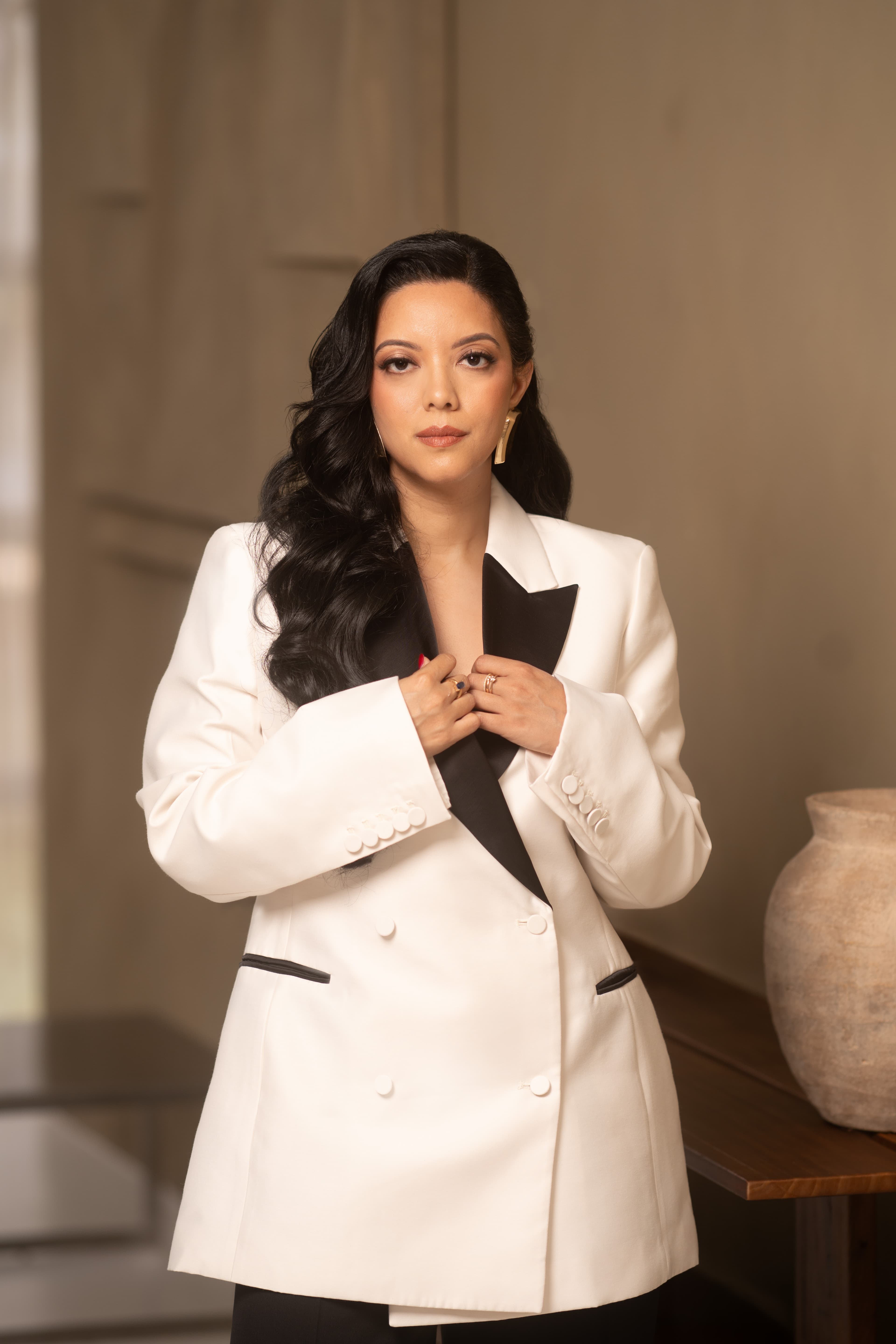 Priscilla Laclé, founder of Oriyé, holding the lapels of her white blazer
